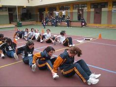 a group of young women sitting on top of a tennis court next to each other