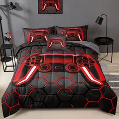 a bed covered in a black and red comforter with video game controllers on it