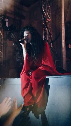 a woman in a red dress on stage