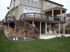 a two story house with stairs leading up to the upper floor and second level balcony