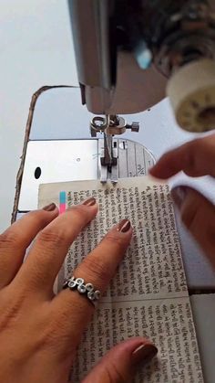 a woman is using a sewing machine to sew on some fabric with her hands