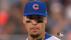 a close up of a baseball player wearing a hat and eyeliners with the chicago cubs on his face