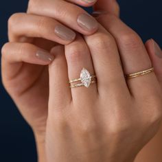 a woman's hand holding a diamond ring