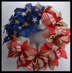 a patriotic wreath with red, white and blue ribbons