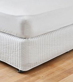 a white mattress is sitting on top of a wooden floor