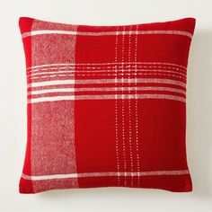 a red and white plaid pillow sitting on top of a wall