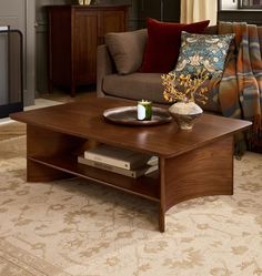 a living room with a couch, coffee table and throw pillows on the rugs