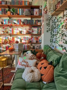 a living room filled with lots of books and stuffed animals on top of green couches