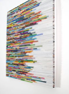 a white wall with a large number of colored pencils on it