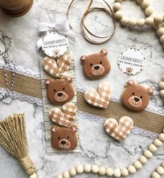 some teddy bears are sitting on a table next to beads and other items that include yarn