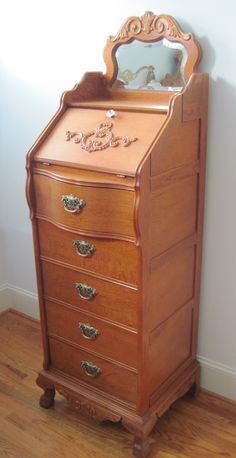 an antique wooden dresser with mirror on top