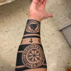 a person's arm with tattoos on it and two compasss in the middle