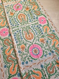 an intricately designed table cloth is laying on the floor