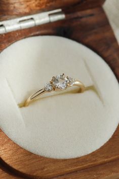 two diamond engagement rings in a wooden box