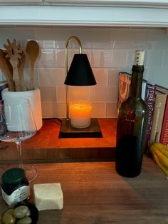 a bottle of wine sitting on top of a counter next to a lamp and some food