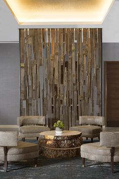 a living room filled with furniture and a large wooden wall hanging over the top of it