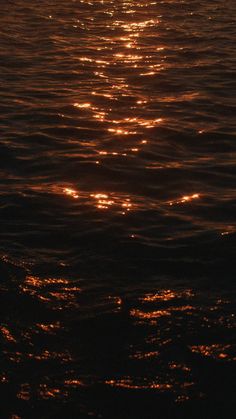 the sun shines brightly on the water as it reflects off in the dark ocean