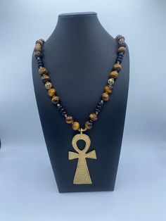 Ankh brass centerpiece with 14mm Onyx and 10mm Apatite  gemstones, accented with Ashanti brass beads.   Length: 25 inches For special deals, updates and promotions  Follow/Favorite Simone's Boutique on Etsy and instagram https://www.instagram.com/sbafrojewelz/ Ankh Necklace Men, Male African Necklace, Amulet Style Ankh Necklace In Brass, Brown Brass Necklace For Healing, Handmade Artisan Ankh Jewelry, Spiritual Brass Jewelry With Polished Beads, Bohemian Ankh-shaped Bronze Jewelry, Bronze Ankh Bohemian Jewelry, Bohemian Ankh Bronze Jewelry