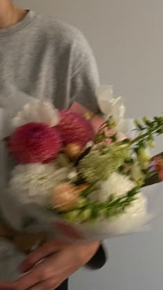 a person holding a bouquet of flowers in their hands