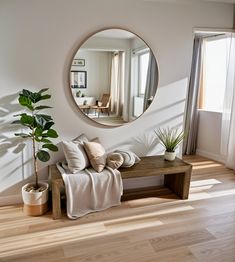 a living room filled with furniture and a round mirror