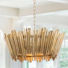 a wooden chandelier hanging from a ceiling in a room with white walls and windows