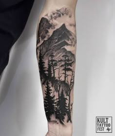 a man's arm with a mountain and trees tattoo on the left side of his arm