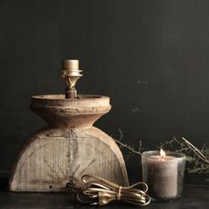 an old fashioned water fountain next to a lit candle