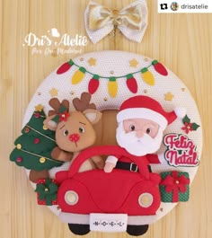 a christmas ornament with santa claus and reindeers in a red car on a wooden surface