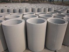 many cement cylinders are lined up on the ground