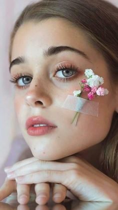 a woman with flowers in her hair and eyeliners is posing for the camera