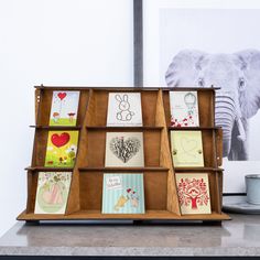 an elephant is standing next to a shelf with greeting cards on it