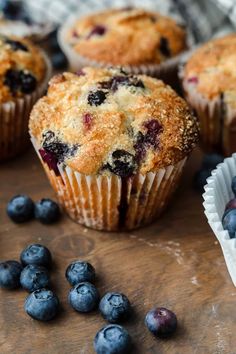 some blueberry muffins are sitting on a table next to fresh blueberries