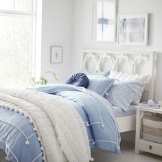 a bed with blue and white comforters in a bedroom