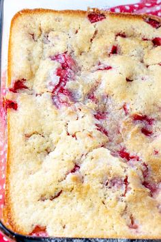 a square cake sitting on top of a red and white checkered cloth covered baking pan