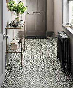 a hallway with an ornate tile floor and walls, along with a radiator