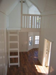 a loft with a ladder to the second floor and a window on the far side