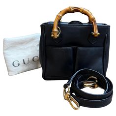 This vintage GUCCI mini 2-way bamboo crossbody bag is crafted of calfskin leather in dark navy featuring gold toned hardware and mini bamboo handles. The front of this mini bag also features two slip pockets. Top magnetic snap flap closure opens to a dark navy fabric interior featuring a zippered pocket. This mini bag also comes with a crossbody strap of the same leather. Made in Italy. Measures approximately 6 x 5.5 x 3 inches Strap drop 19 inches. Comes with dustbag and crossbody strap. Condit Gucci Shoulder Bag With Bamboo Handle For Daily Use, Leather Crossbody Shoulder Bag With Bamboo Handle, Classic Gucci Bag With Bamboo Handle, Gucci Black Shoulder Bag With Bamboo Handle, Gucci Black Bag With Bamboo Handle, Black Gucci Bag With Bamboo Handle, Leather Crossbody Bag With Bamboo Handle, Gucci Vintage Bag, Gucci Mini