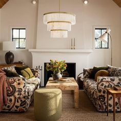 a living room with two couches and a coffee table in front of a fire place