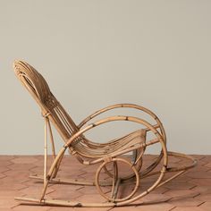 a wooden rocking chair sitting on top of a brick floor