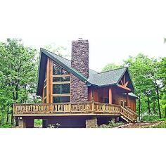 a large log cabin with a wraparound deck and stone fireplace on the front porch