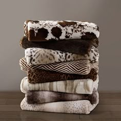 a stack of blankets sitting on top of a wooden floor