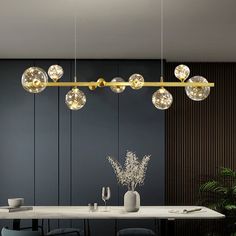 a dining room with a table, chairs and chandelier hanging from the ceiling