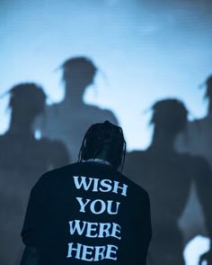 a man standing in front of a projected image with the words wish you were here