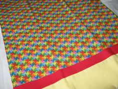 a multicolored square shaped fabric on top of a bed