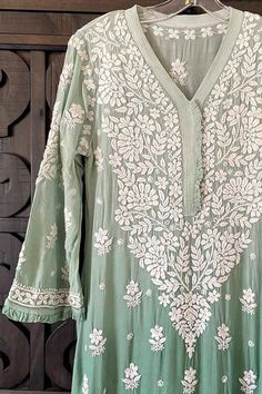 This Ombre Green Lucknowi Chikankari Muslin Kaj Patti Frill Kurti is a staple for any wardrobe. Crafted from Muslin Silk, this piece offers a stylish, elegant look with a frill design detail on the neck and sleeves. A-Line Muslin silk Length 45" inches Long sleeves 18" inches V neck Chikankari embroidery Hand embroidered Dry Clean Fit: True to sizeInside Margin: NoTouch and Feel: Soft and ComfortableDispatched in 1-3 business days Disclaimer: Since the product is hand embroidered, Motifs may var Phulkari Pants, Lehenga Green, Lucknowi Kurta, Chikankari Lehenga, Ombre Green, Chikankari Embroidery, Trendy Outfits Indian, Lucknowi Chikankari, Embroidered Motifs