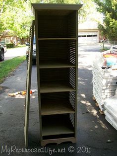 an empty book shelf sitting in the middle of a driveway