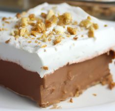 a piece of cake with white frosting and nuts on top