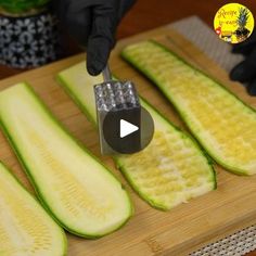 someone cutting up some cucumbers on a wooden board