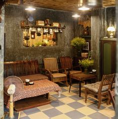 a living room filled with lots of furniture next to a wall covered in potted plants