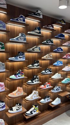 a display case filled with lots of different types of shoes on wooden shelvings